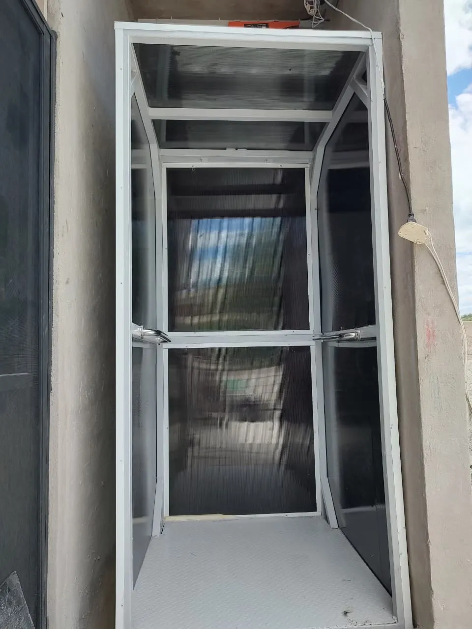 Elevador exterior con cerramiento de policarbonato instalado en la fachada de una vivienda